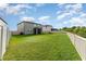 Expansive backyard, fully fenced with manicured lawn, offers ample space for outdoor activities and relaxation at 13532 Palmera Vista Dr, Riverview, FL 33579