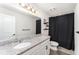 Clean bathroom design with granite counters, modern vanity, and a shower with black curtain, maximizing space at 13532 Palmera Vista Dr, Riverview, FL 33579