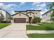 Charming two-story home features a manicured lawn, two-car garage, and inviting entryway at 13532 Palmera Vista Dr, Riverview, FL 33579