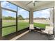 Screened porch featuring cozy chairs, perfect for enjoying the view of the expansive and well-maintained backyard at 13532 Palmera Vista Dr, Riverview, FL 33579