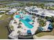 Aerial view of the community clubhouse, featuring sparkling pools and ample seating, surrounded by lush landscaping at 18743 Coastal Shore Ter, Land O Lakes, FL 34638