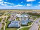 Aerial view of a clubhouse with pools, tennis courts, and landscaping at 18743 Coastal Shore Ter, Land O Lakes, FL 34638