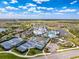 Aerial view of community amenities: tennis courts, pool, clubhouse, gardens, parking & nearby roadway at 18743 Coastal Shore Ter, Land O Lakes, FL 34638