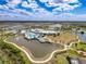 An aerial view of a Primary-planned community, showcasing a resort-style pool, clubhouse, and picturesque lake views at 18743 Coastal Shore Ter, Land O Lakes, FL 34638