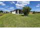 Well-maintained lawn with tree and a screened-in lanai provides privacy and shade at 18743 Coastal Shore Ter, Land O Lakes, FL 34638