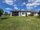 Back exterior of home with manicured lawn, screened-in porch, and carefully placed landscaping at 18743 Coastal Shore Ter, Land O Lakes, FL 34638