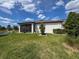 Exterior view of home featuring a well-kept lawn, screened-in patio, and tasteful landscaping at 18743 Coastal Shore Ter, Land O Lakes, FL 34638