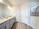 Bathroom featuring double sinks, granite countertops, and a tiled shower at 18743 Coastal Shore Ter, Land O Lakes, FL 34638