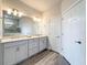 Beautiful bathroom featuring double sinks with a tiled shower and a large mirror at 18743 Coastal Shore Ter, Land O Lakes, FL 34638