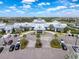 Aerial view of a large community center featuring tropical landscaping and an entrance with ample parking at 18743 Coastal Shore Ter, Land O Lakes, FL 34638