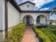 Inviting front entrance with brick pathway, decorative arches, and manicured green hedges at 18743 Coastal Shore Ter, Land O Lakes, FL 34638