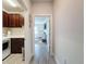 Hallway view into bedroom with tile floor and laundry room to the left at 18743 Coastal Shore Ter, Land O Lakes, FL 34638