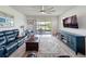 Open living room with outdoor views, comfortable couches, a ceiling fan and an entertainment center at 18743 Coastal Shore Ter, Land O Lakes, FL 34638