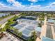 Aerial view of multiple blue outdoor pickleball courts in a gated community surrounded by palm trees, and blue skies at 18743 Coastal Shore Ter, Land O Lakes, FL 34638