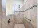 Walk in shower with stone floors and walls, modern shower head and handle, and glass partition at 18743 Coastal Shore Ter, Land O Lakes, FL 34638