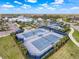 Aerial view of multiple well-maintained, blue tennis courts in a gated community with a community center at 18743 Coastal Shore Ter, Land O Lakes, FL 34638