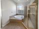 Bright bathroom featuring a garden tub and glass enclosed shower at 4249 Hawksley Pl, Wesley Chapel, FL 33545