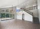 Spacious living room with tile floors, high ceilings, decorative lighting, and a staircase to the second floor at 4249 Hawksley Pl, Wesley Chapel, FL 33545