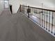 Carpeted loft with decorative iron railing overlooking the living room at 4249 Hawksley Pl, Wesley Chapel, FL 33545