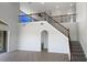 Living room staircase featuring tile floors, high ceilings, decorative lighting, and wood banister at 4249 Hawksley Pl, Wesley Chapel, FL 33545