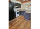 Modest kitchen with black appliances, tile countertops, ample cabinetry, and hardwood floors at 12627 W Cherrydale Ln, Hudson, FL 34669