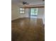 Spacious living room featuring neutral walls, a ceiling fan, and sliding glass doors at 12627 W Cherrydale Ln, Hudson, FL 34669