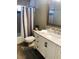 Well-lit bathroom with a gray vanity, ample counter space, and decorative mirror at 201 Chardin Dr, Nokomis, FL 34275