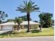 Charming single-story home with a well-manicured lawn and mature palm tree at 201 Chardin Dr, Nokomis, FL 34275