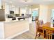 Open concept kitchen featuring white cabinets, granite counters and stainless appliances at 201 Chardin Dr, Nokomis, FL 34275