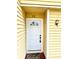 Close-up of the front door with white trim and a decorative light fixture at 22620 Gage Loop # 25, Land O Lakes, FL 34639
