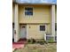 Two-story townhome with yellow siding, white trim, and a cozy front entrance at 22620 Gage Loop # 25, Land O Lakes, FL 34639