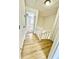 Hallway with wood flooring, white doors, and access to the stairs at 22620 Gage Loop # 25, Land O Lakes, FL 34639