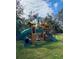 Outdoor playground with a green slide, rock climbing wall, swing set, and covered clubhouse at 22620 Gage Loop # 25, Land O Lakes, FL 34639