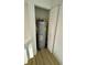 Small utility closet shows the hot water heater, with white shelving above, and light wood-colored flooring at 22620 Gage Loop # 25, Land O Lakes, FL 34639
