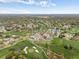 Panoramic aerial showcasing the community's golf course, pool, clubhouse, and surrounding residential area at 2436 Deer Trail Ln, Spring Hill, FL 34606