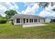 Well-maintained backyard featuring a stone patio, verdant grass, and partial home exterior at 2436 Deer Trail Ln, Spring Hill, FL 34606