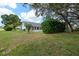 Spacious backyard featuring lush green grass, mature trees, providing a private and serene outdoor space at 2436 Deer Trail Ln, Spring Hill, FL 34606
