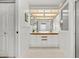 Bright bathroom with double vanity, a mirror with overhead lighting, and neutral tiling at 2436 Deer Trail Ln, Spring Hill, FL 34606