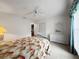 Bedroom with white walls and ceiling fan, featuring a large window and dresser with mirror at 2436 Deer Trail Ln, Spring Hill, FL 34606