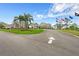 A well-maintained driveway leading up to a beautiful clubhouse with manicured landscaping at 2436 Deer Trail Ln, Spring Hill, FL 34606