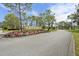 A picturesque entry to this community featuring a brick sign and colorful flower bed at 2436 Deer Trail Ln, Spring Hill, FL 34606