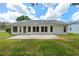 Rear view of a home showcasing a large brick patio, perfect for outdoor gatherings at 2436 Deer Trail Ln, Spring Hill, FL 34606