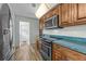 Cozy kitchen featuring wood cabinets, stainless steel appliances, and a stylish backsplash at 2436 Deer Trail Ln, Spring Hill, FL 34606