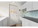Functional laundry area with a sink, countertop, and white cabinets for ample storage at 2436 Deer Trail Ln, Spring Hill, FL 34606