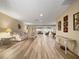 Bright open-plan living room boasts wood-look tile flooring, neutral walls, and views to the dining and seating areas at 2436 Deer Trail Ln, Spring Hill, FL 34606