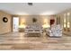 Comfortable living room with wood-look tile floors, neutral walls, and comfortable seating at 2436 Deer Trail Ln, Spring Hill, FL 34606