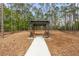 Outdoor seating area featuring a wooden pergola, two chairs and landscaping along a walking path at 2436 Deer Trail Ln, Spring Hill, FL 34606
