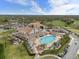 Aerial view of resort-style pool, golf course, and community clubhouse, surrounded by lush greenery and amenities at 2444 Grandfather Mtn, Spring Hill, FL 34606