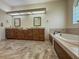 Bright bathroom with double vanities, a soaking tub, a glass-enclosed shower, and tile flooring at 2444 Grandfather Mtn, Spring Hill, FL 34606