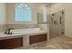 Beautiful bathroom featuring a soaking tub, a glass-enclosed shower, and tile flooring at 2444 Grandfather Mtn, Spring Hill, FL 34606